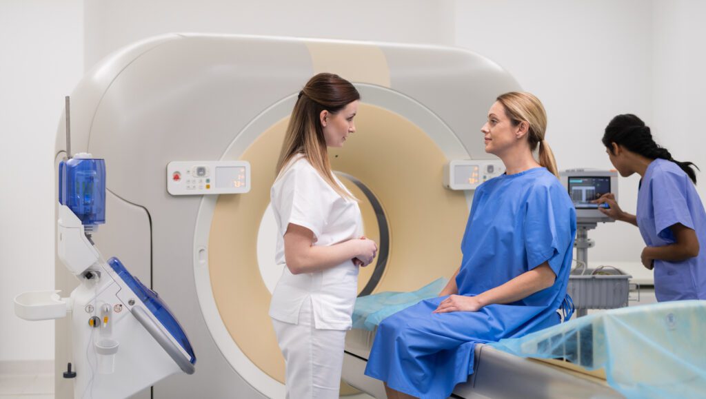 Doctor giving information to woman before MRI scan examination. Magnetic resonance imaging technology in specialized medical clinic.